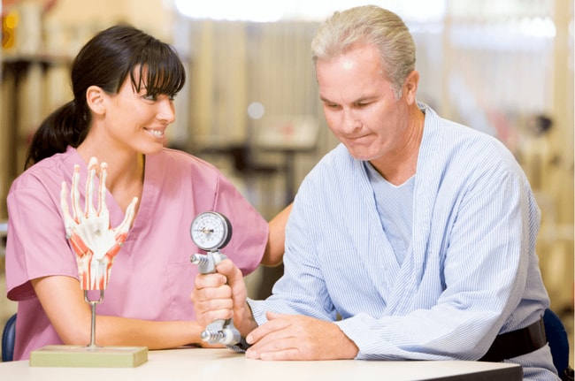 PhysicalGripOptimized Man testing grip strength with smiling nurse